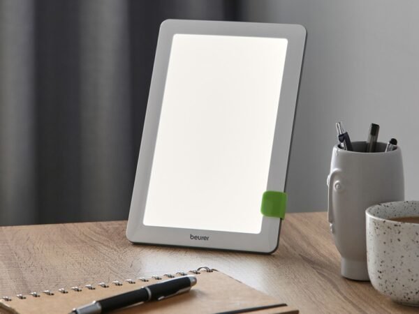Lampe Beurer TL 30 blanche avec support vert sur une table